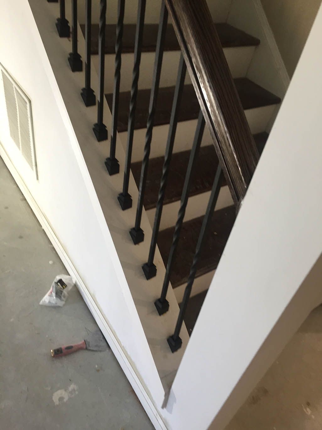 A staircase with a wrought iron railing and wooden steps