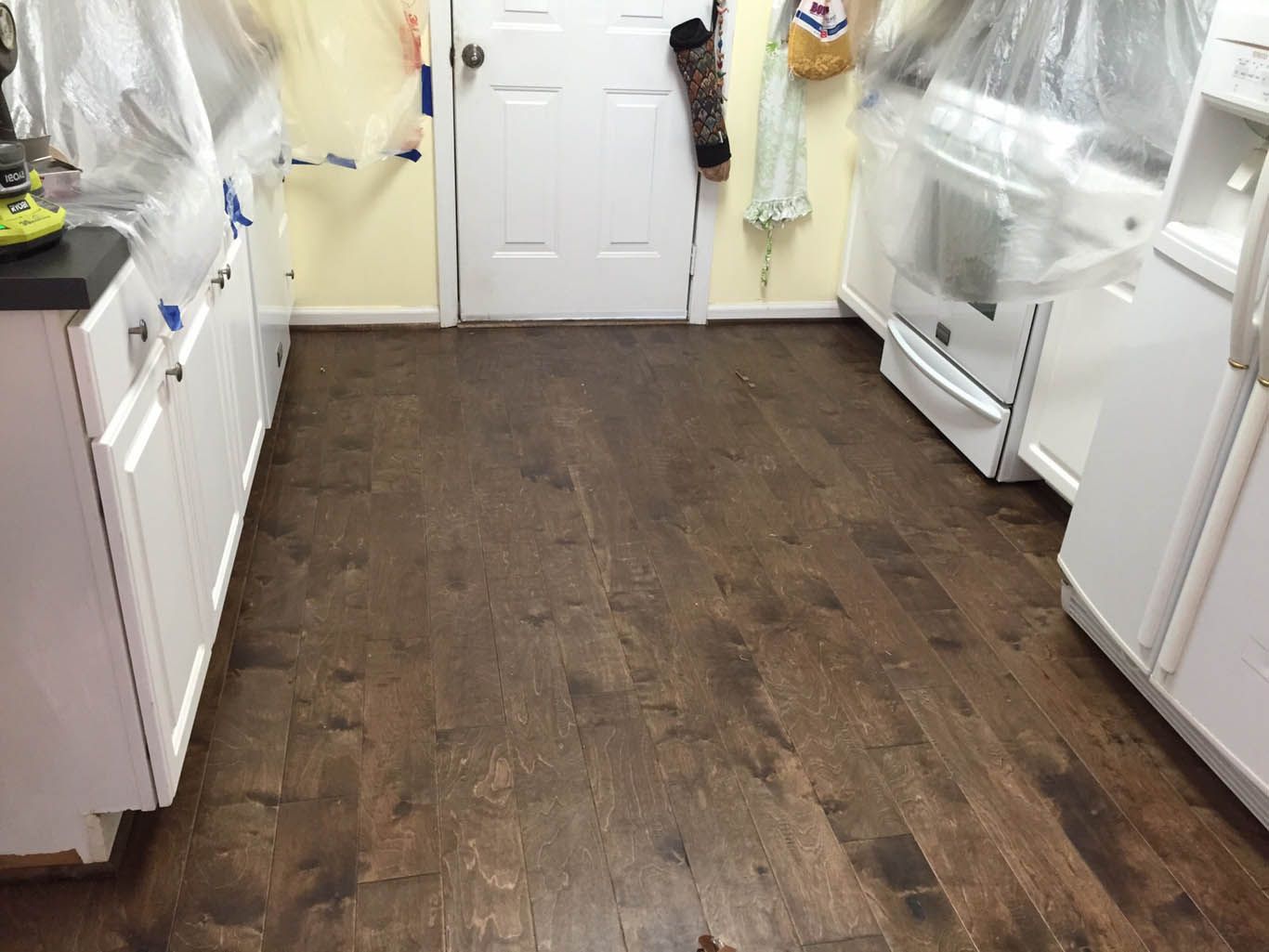 A kitchen with hardwood floors and white cabinets.
