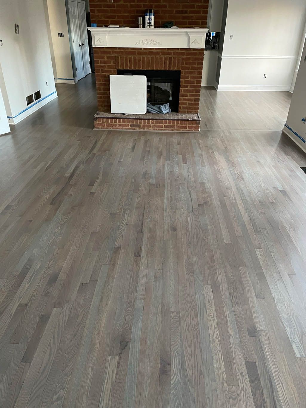 A living room with hardwood floors and a fireplace.