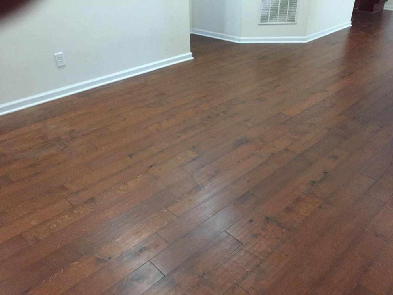 A living room with hardwood floors and white walls.