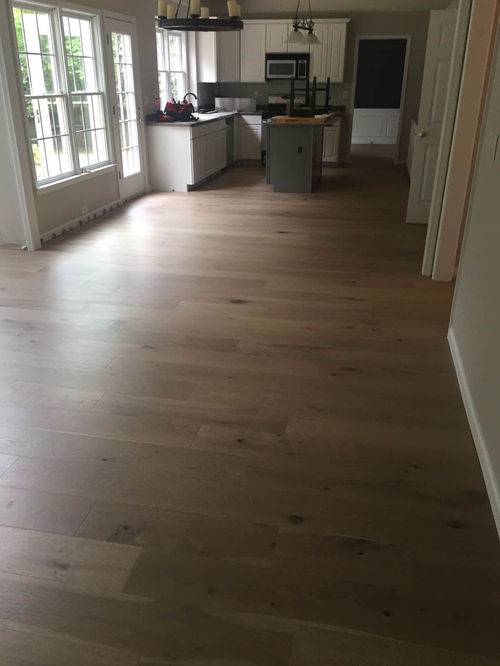 A kitchen with hardwood floors and a large island in the middle of the room.