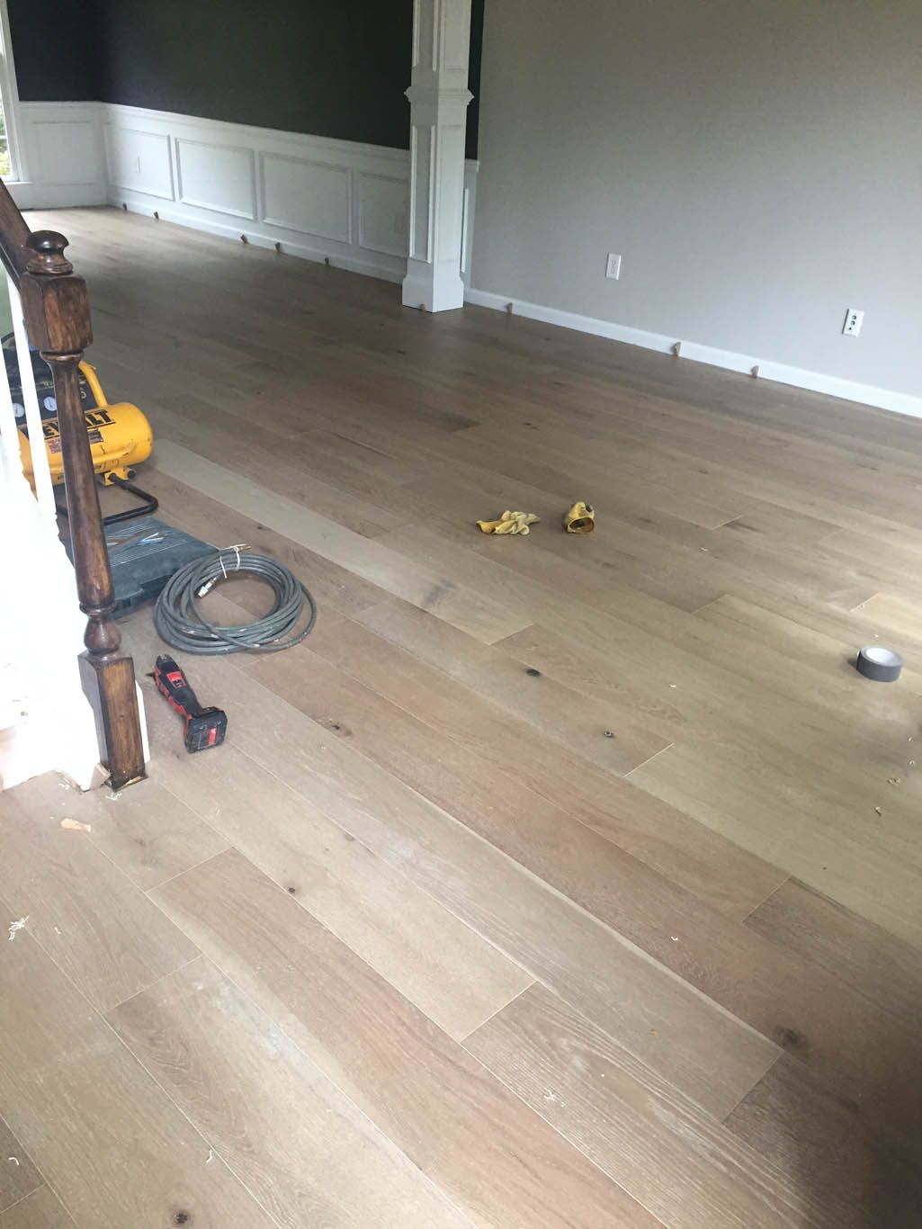 A wooden floor is being installed in a living room.
