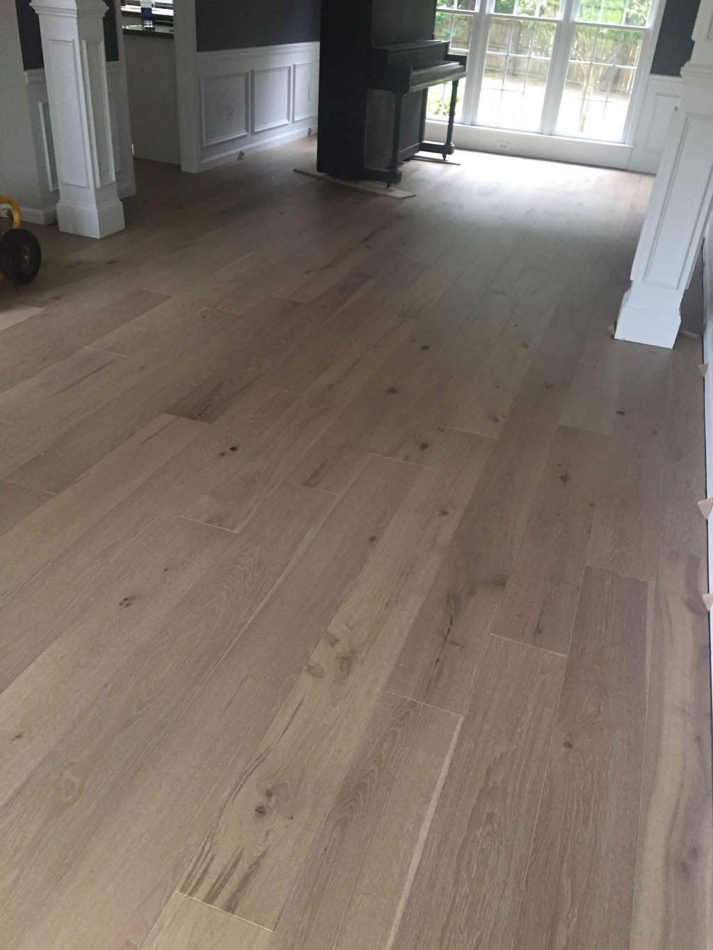 A living room with a wooden floor and a fireplace.