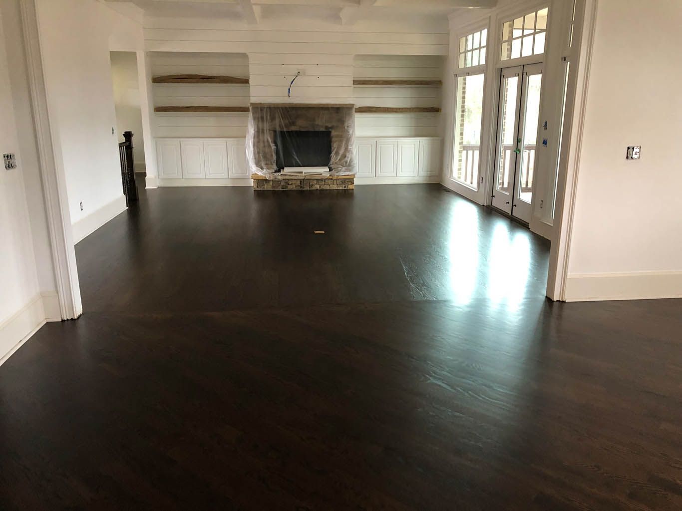 An empty living room with hardwood floors and a fireplace.