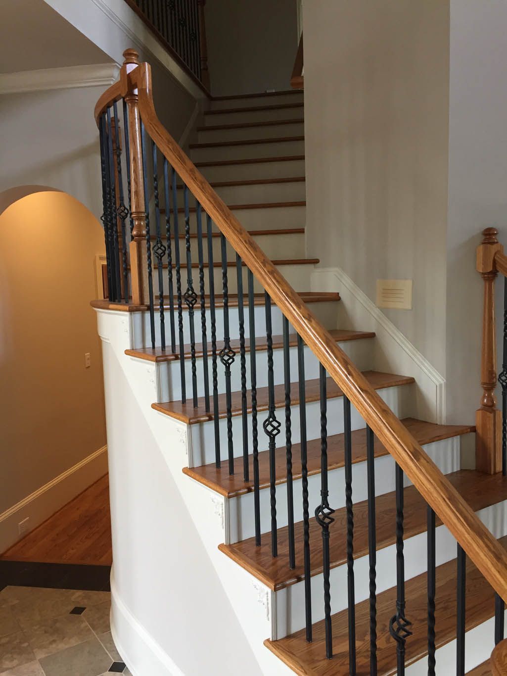 A wooden staircase with a metal railing in a house