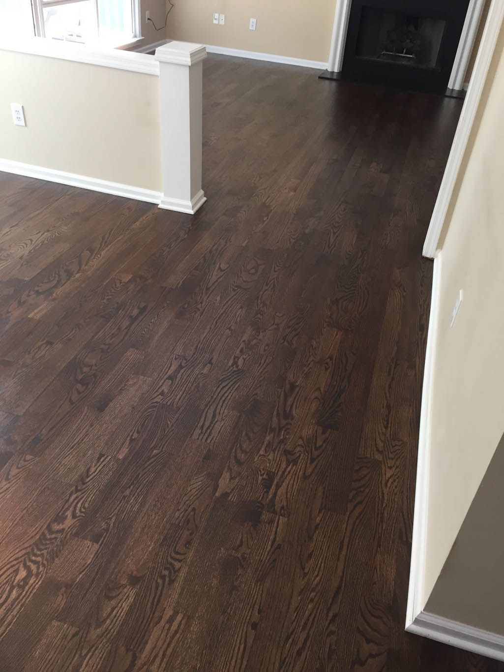 A living room with hardwood floors and a fireplace.