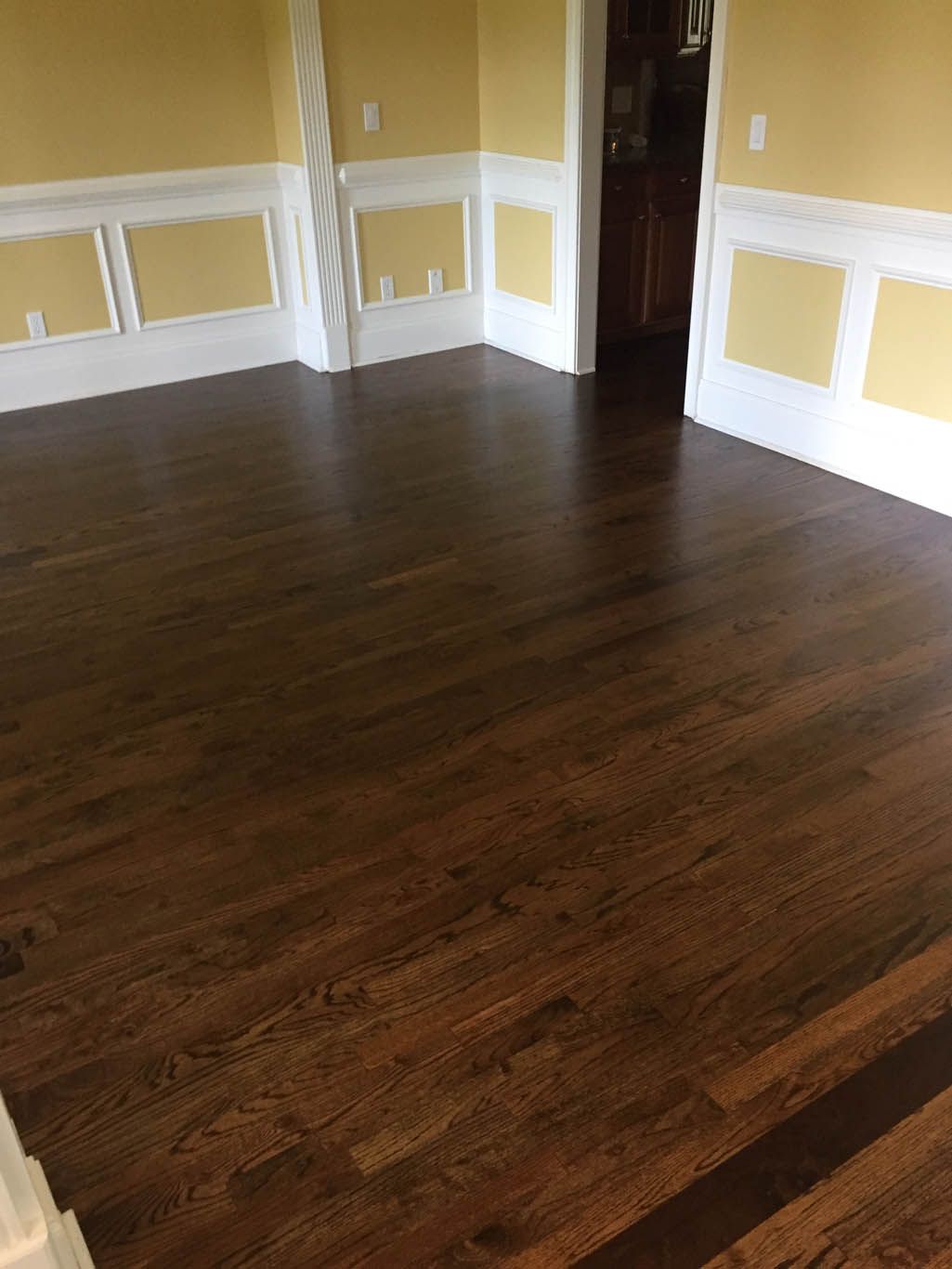 A living room with hardwood floors and yellow walls.