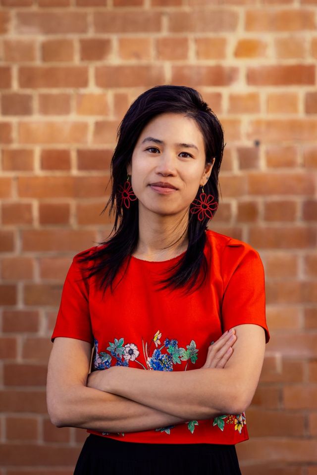Yingna Lu of Spaceboy Studio. A woman with dark hair, wearing a red top, with arms crossed