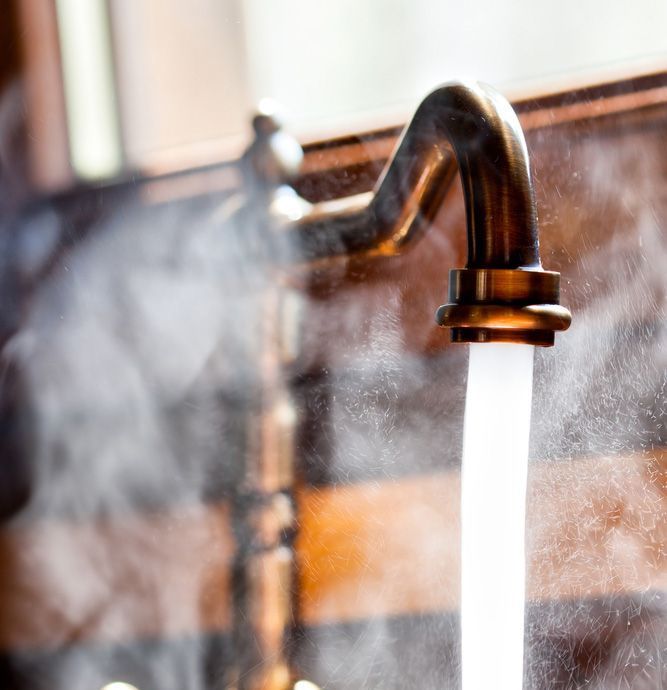 A Close Up Of A Faucet With Steam Coming Out Of It — Advantage Plumbing Solutions In Maryland, NSW