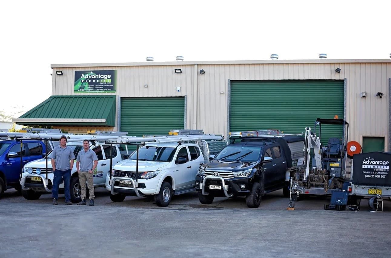 A Group Of Trucks Are Parked In Front Of A Building — Advantage Plumbing Solutions In Gateshead, NSW