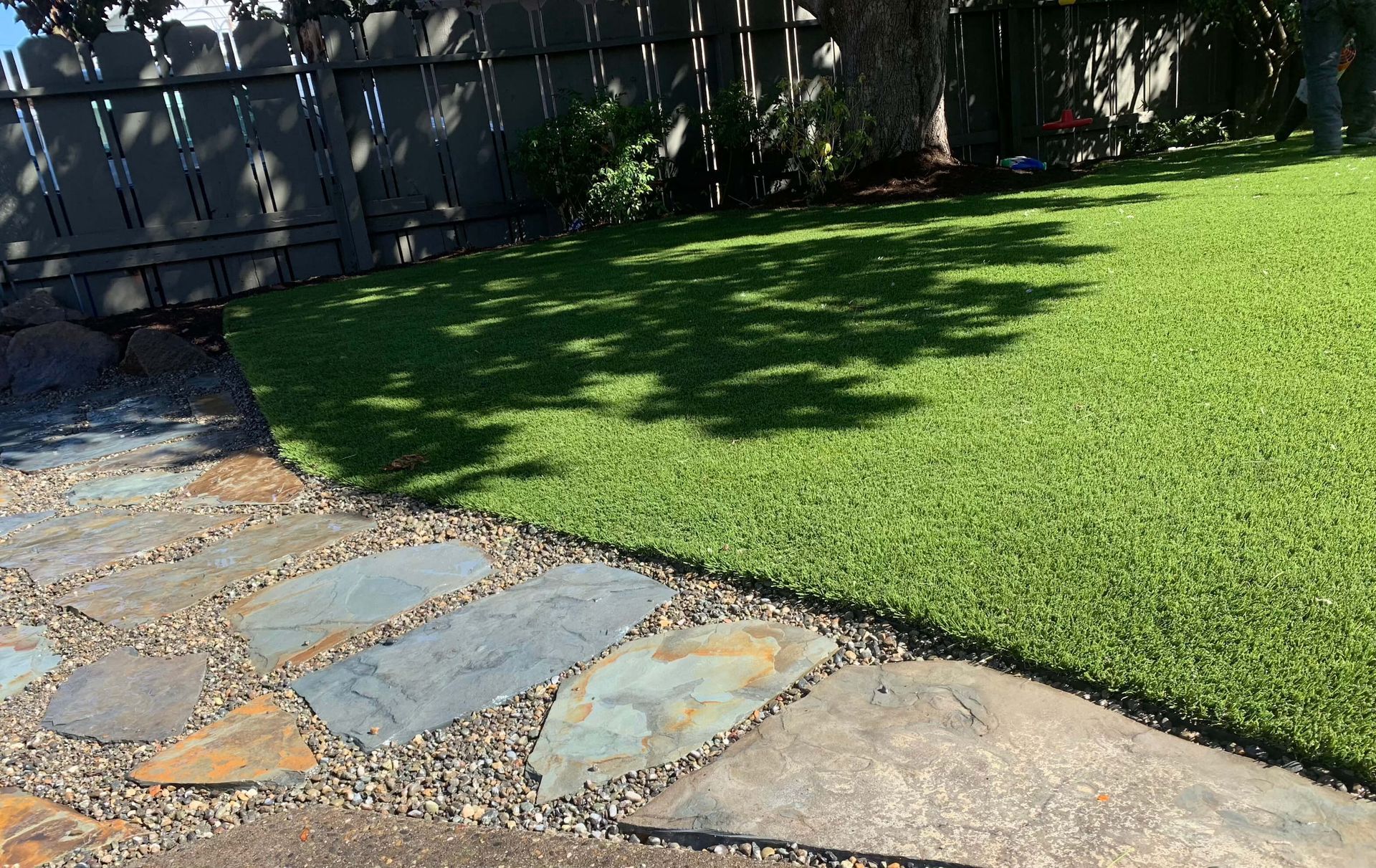 A stone walkway leading to a lush green lawn