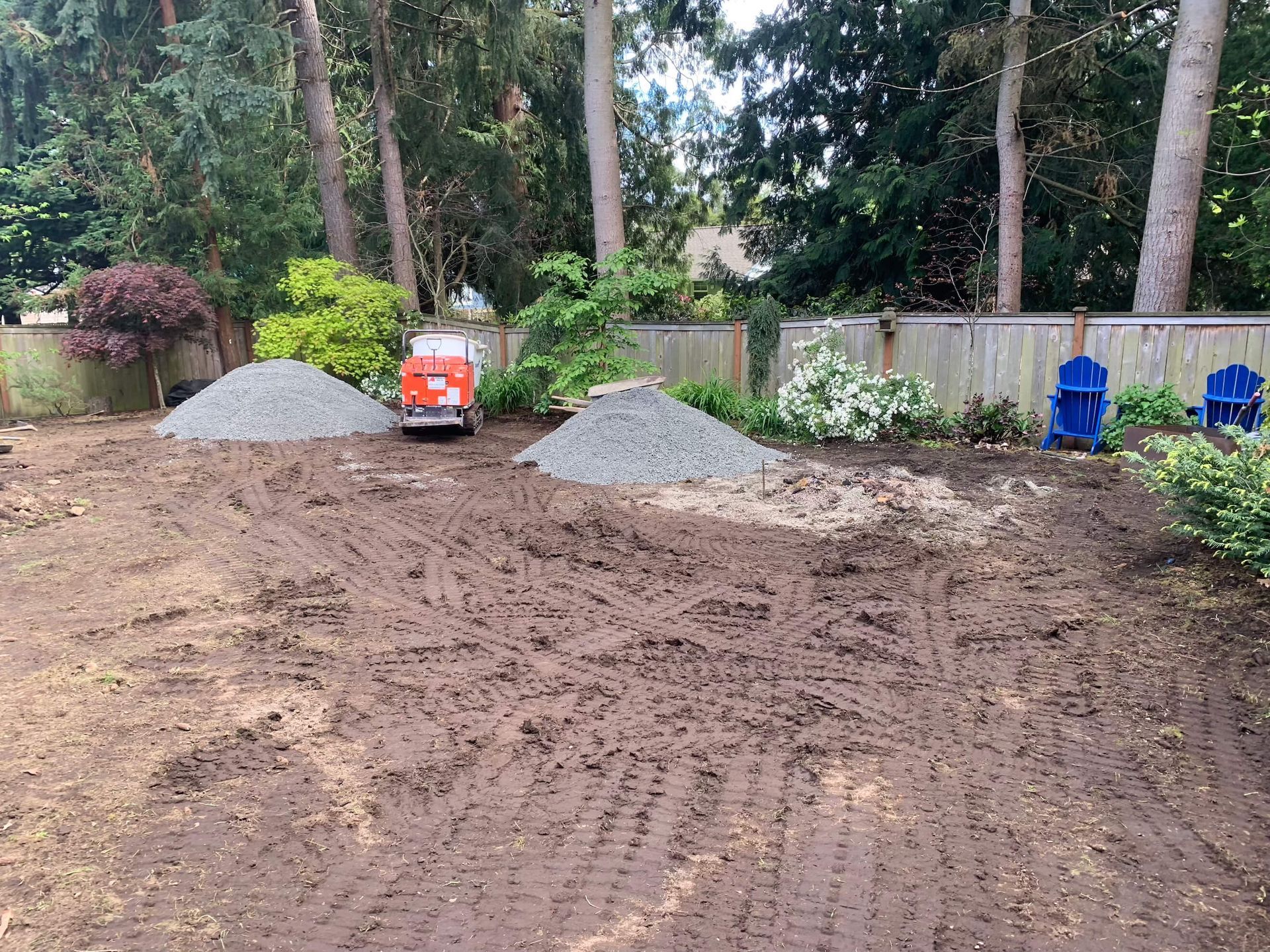 A pile of gravel is sitting in the middle of a dirt field.