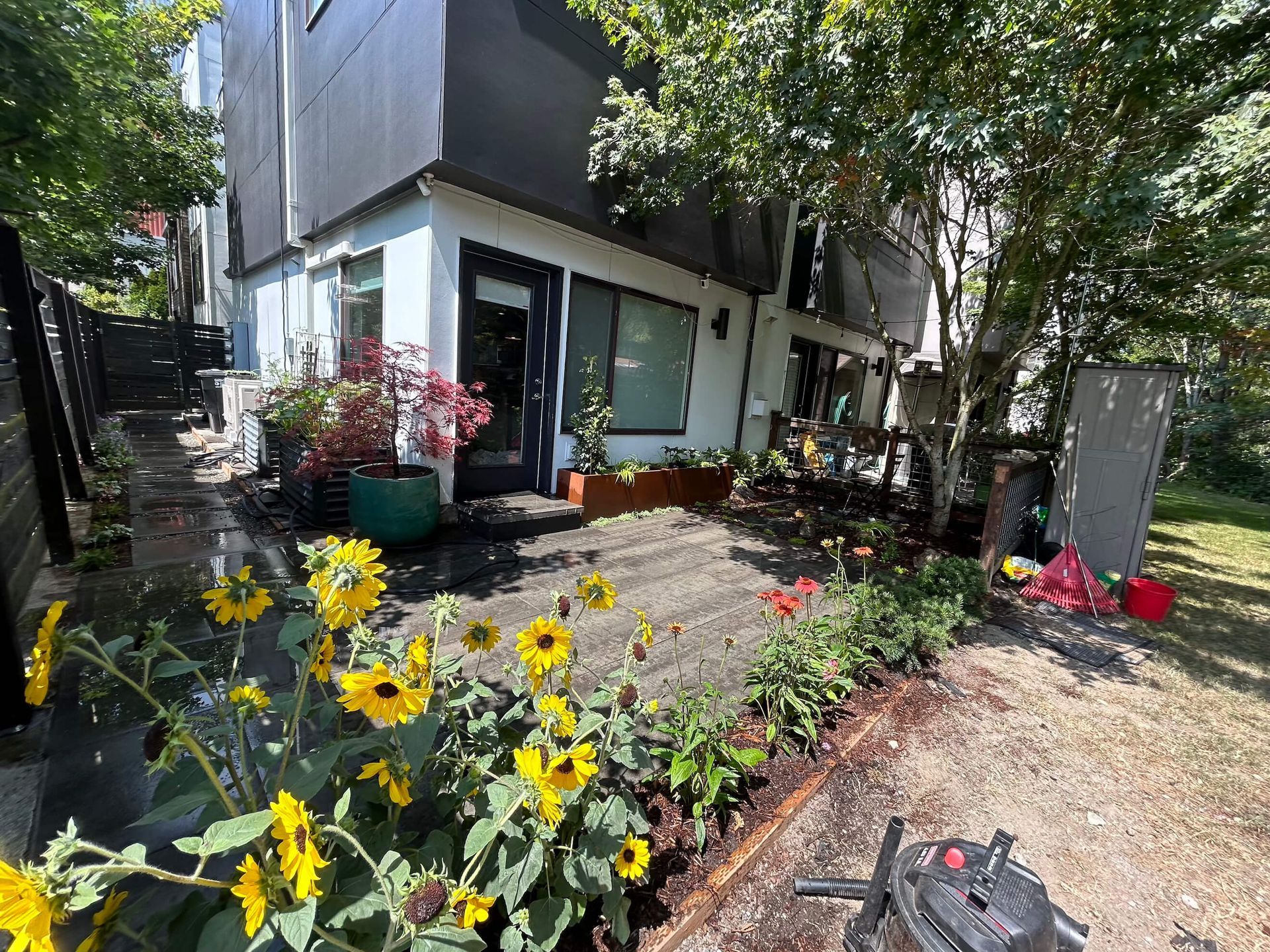 A house with a patio and flowers in front of it.