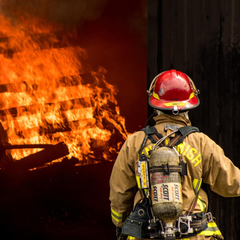 A firefighter approaching a house fire