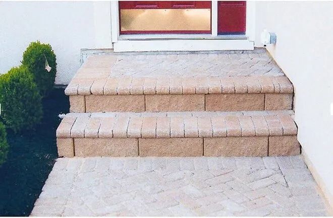 A set of brick steps leading up to a red door