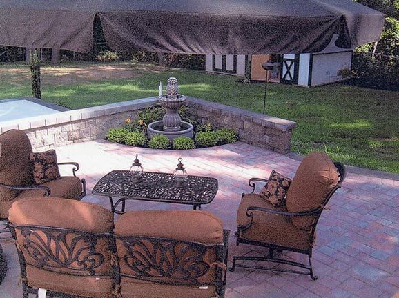 A patio with furniture and a fountain in the background