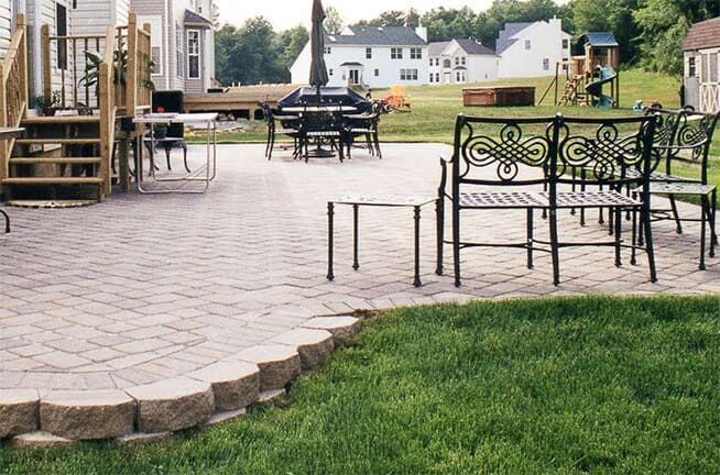 A patio with chairs and tables in front of a house