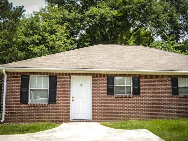Building exterior with brick and black shudders