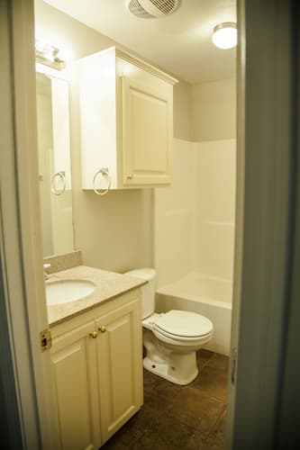 Full bathroom with small vanity and cabinet above toilet