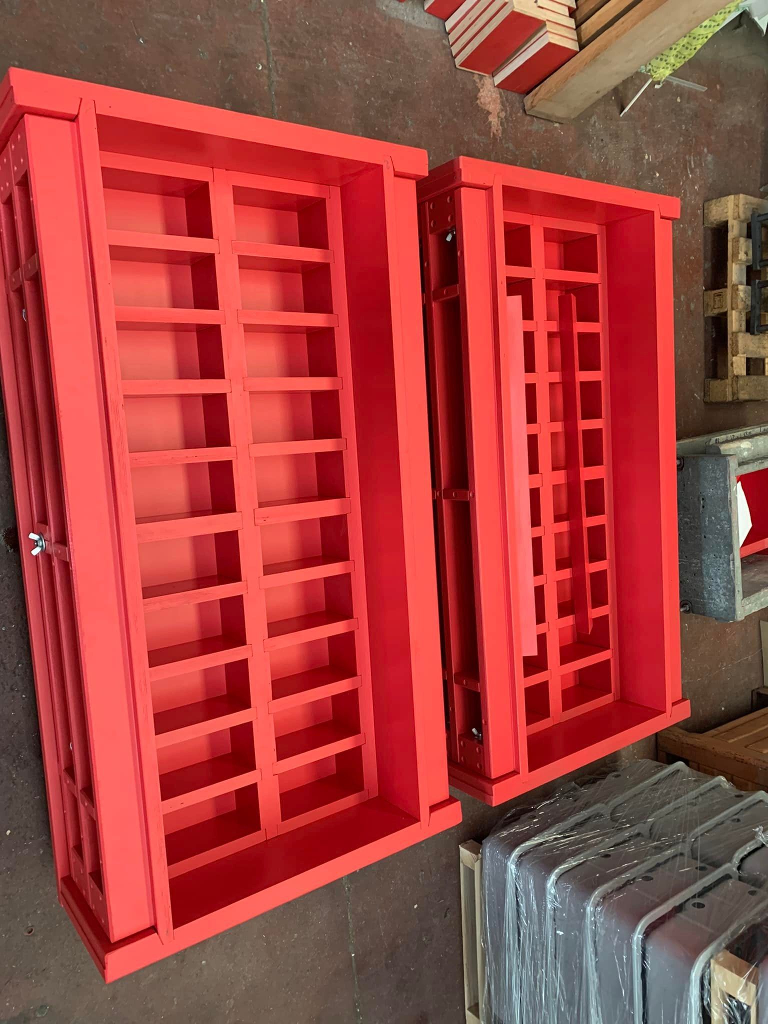 Due cornici di finestre rosse e rettangolari, una accanto all'altra, su una superficie marrone.