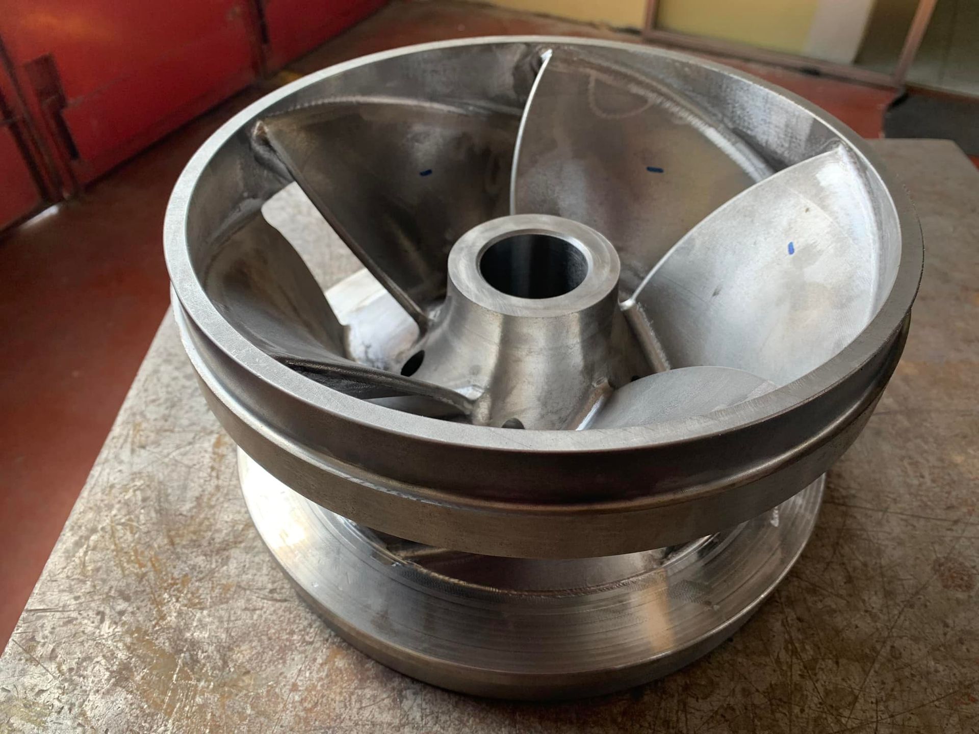 Girante metallica con pale curve, utilizzata in una pompa per spostare fluidi.