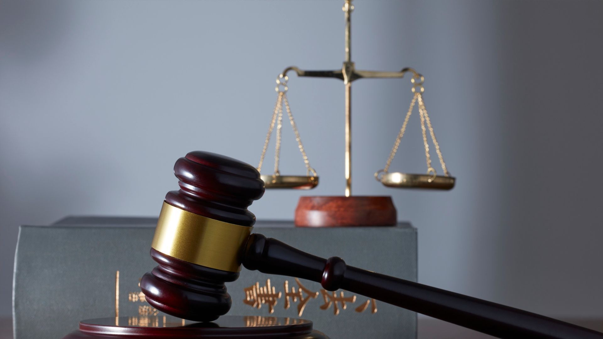A judge 's gavel is sitting on a table next to a scale of justice.