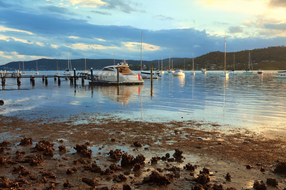 A Boat Is Docked In The Water Near A Dock — Coastline Air In Gosford, NSW