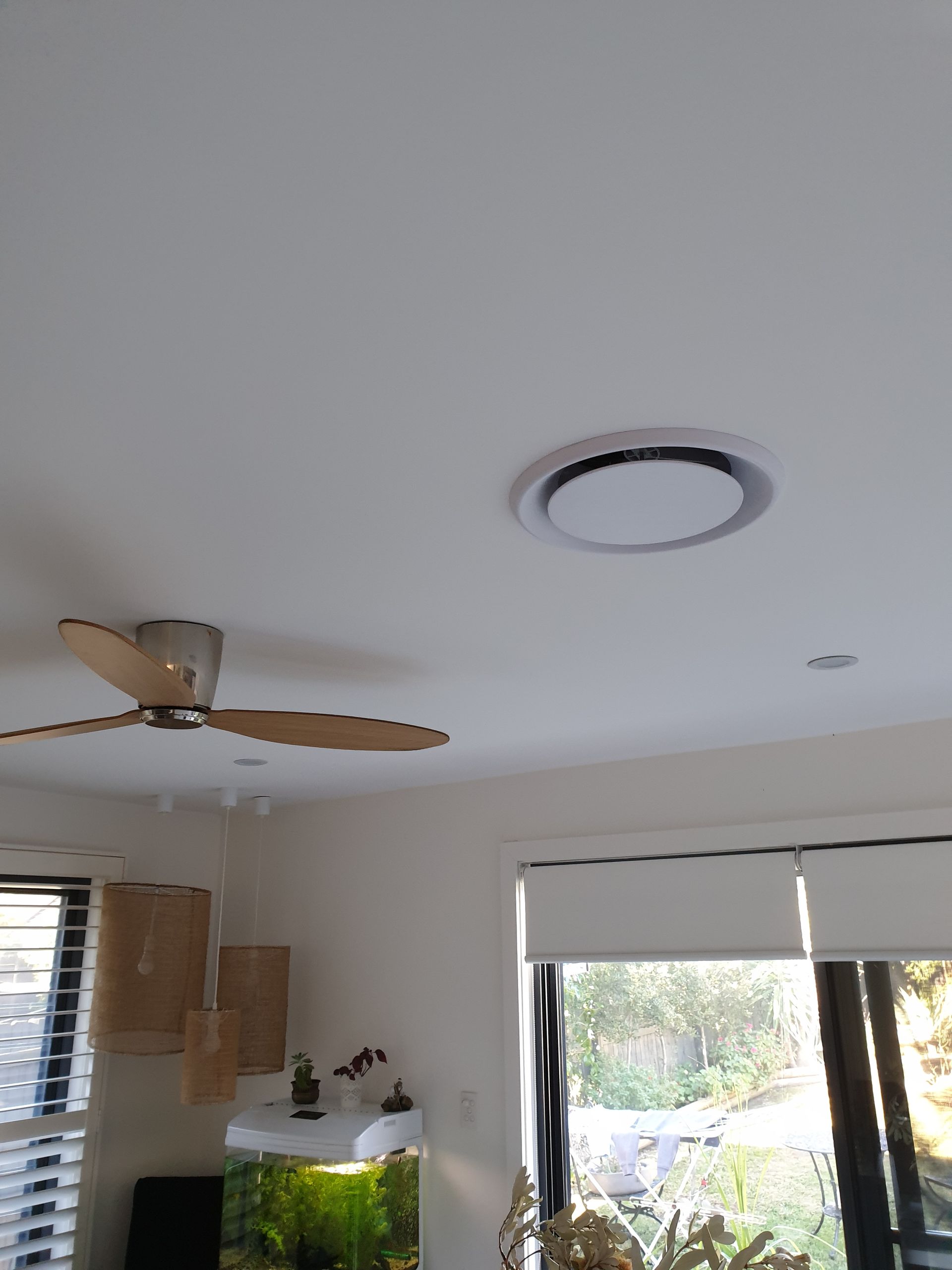 A living room with a ceiling fan and a window. — Coastline Air In Forresters Beach, NSW