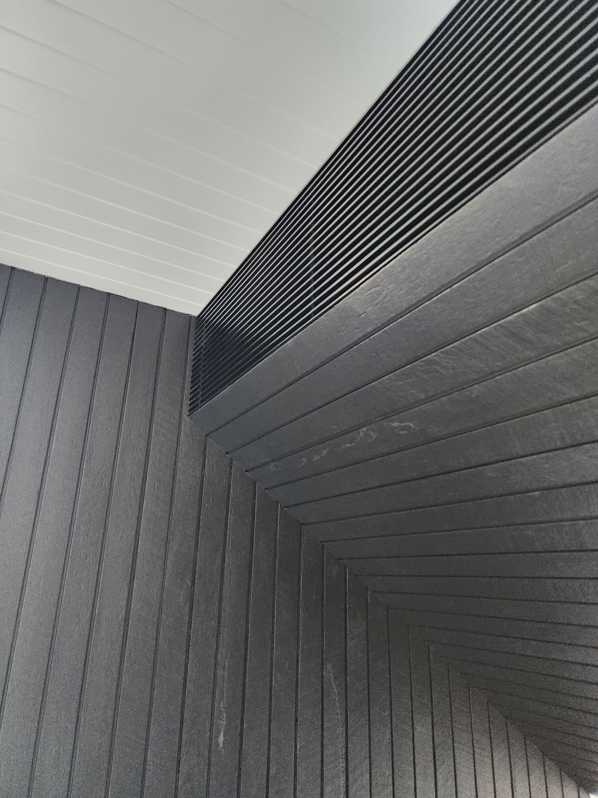A close up of a corner of a room with a black wall and a white ceiling. — Coastline Air In Forresters Beach, NSW
