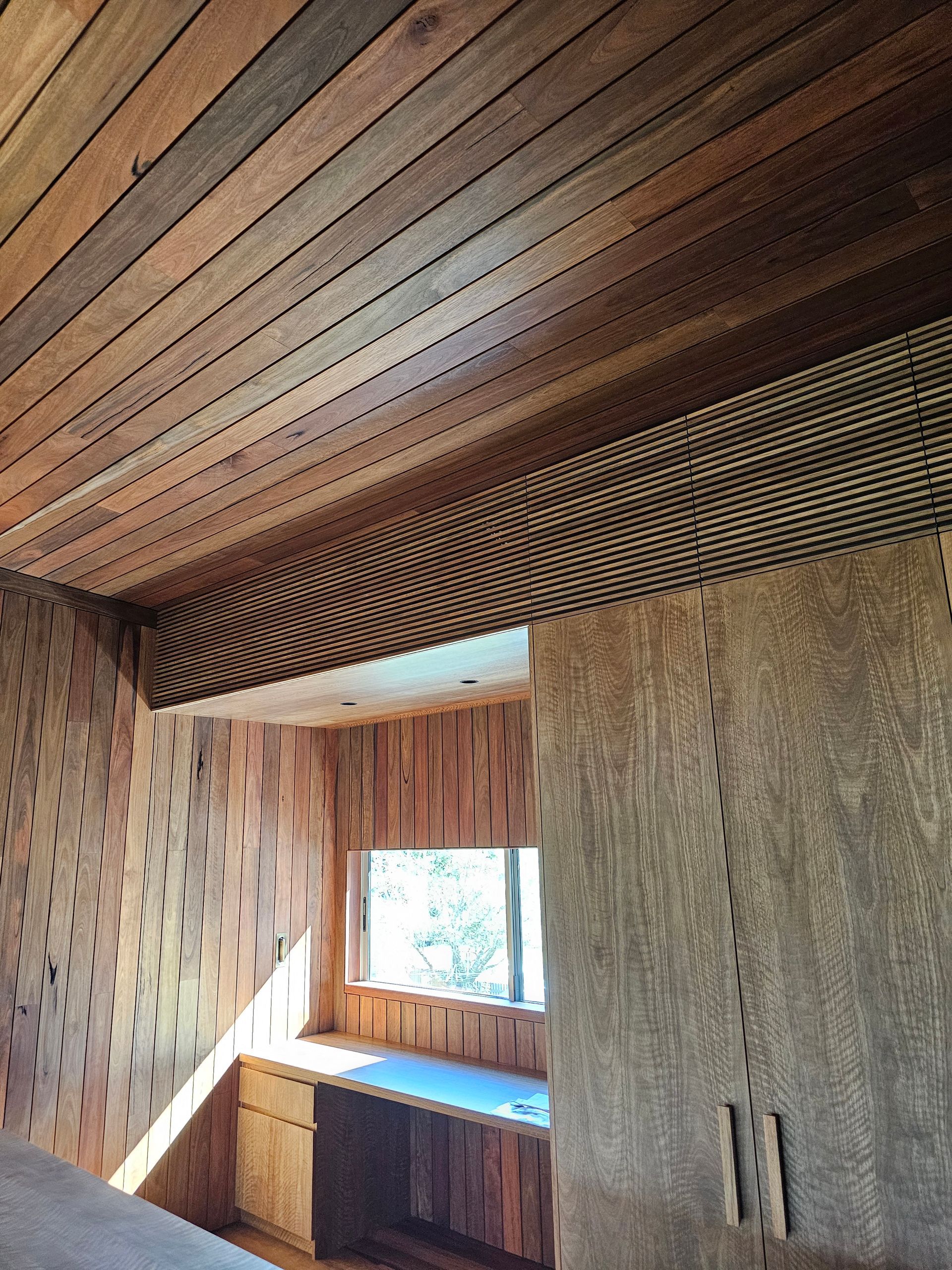 A room with a wooden ceiling and a window — Coastline Air In Forresters Beach, NSW