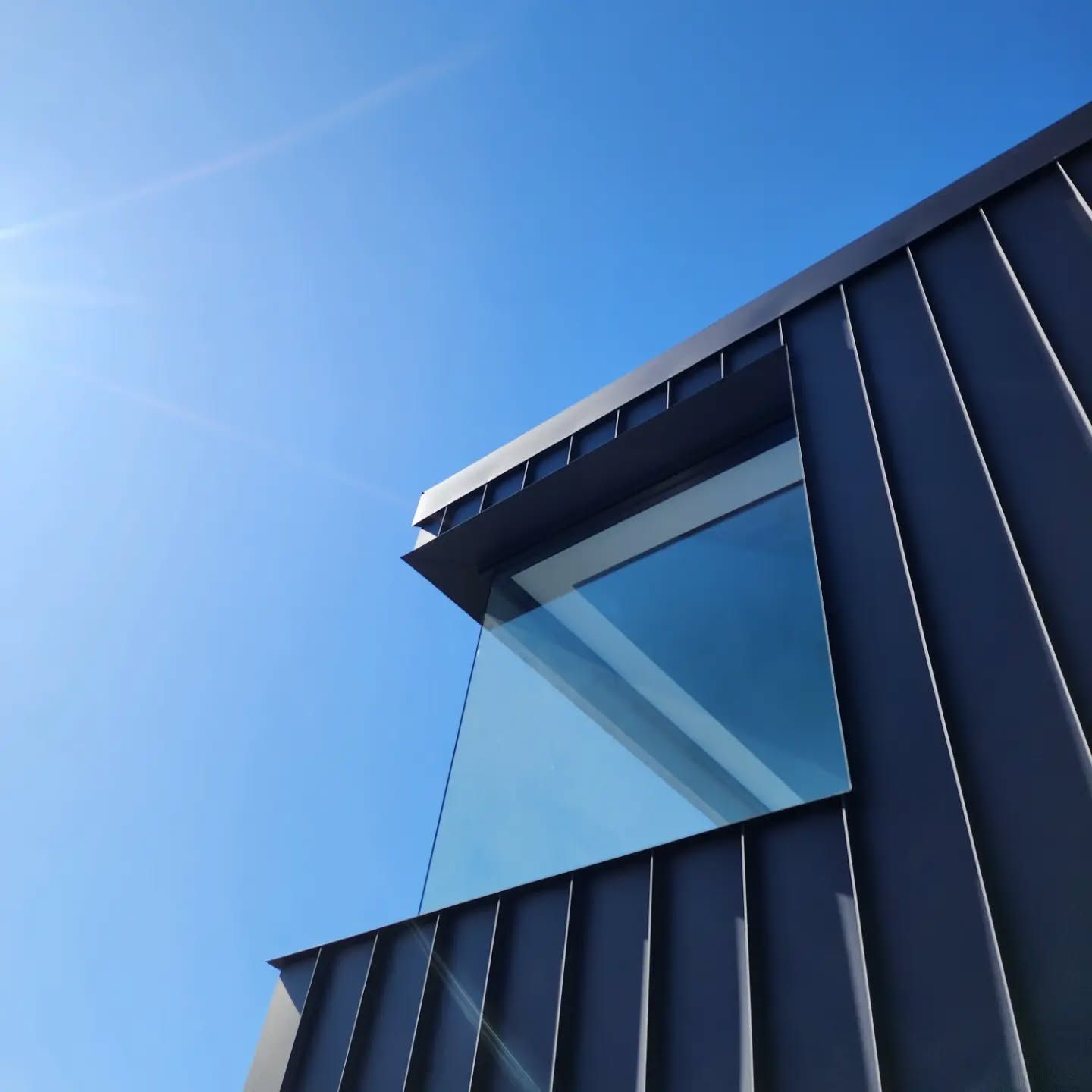 A Corner Of A New Building With A Large Window And Ribbed Cladding — Coastline Air In Forresters Beach, NSW