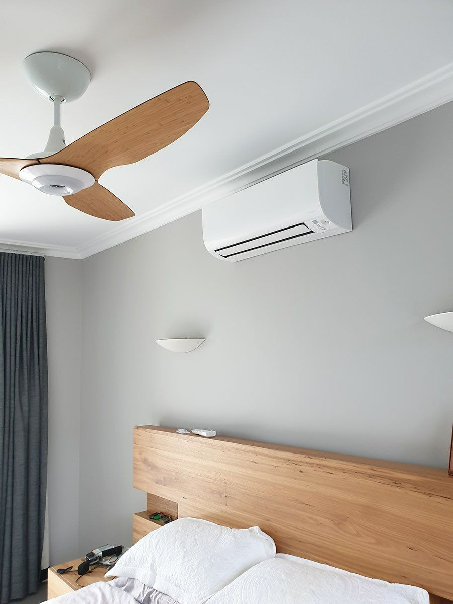 A Bedroom With A Bed , Ceiling Fan , And Air Conditioner — Coastline Air In Forresters Beach, NSW