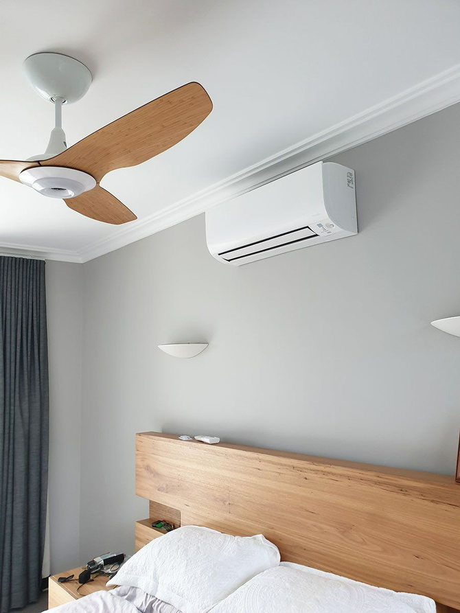 A Bedroom With A Bed , Ceiling Fan , And Air Conditioner — Coastline Air In Forresters Beach, NSW