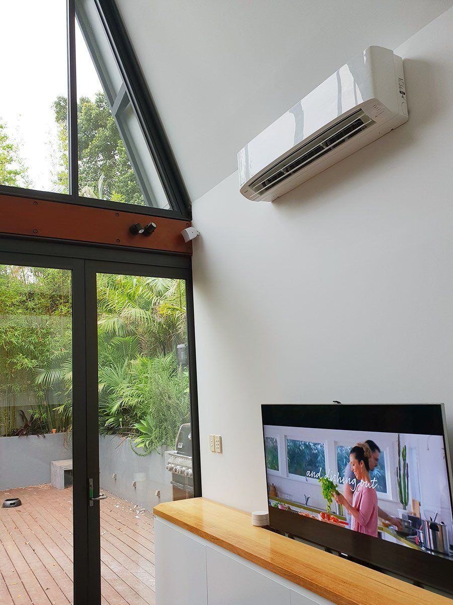 A Living Room With A Television And Air Conditioner On The Wall — Coastline Air In Forresters Beach, NSW