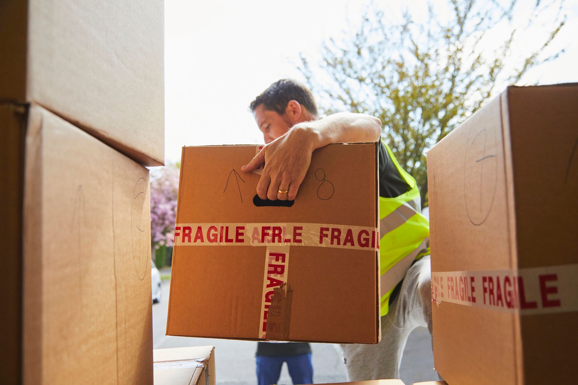 Professional mover unloading boxes from a truck during a commercial relocation.