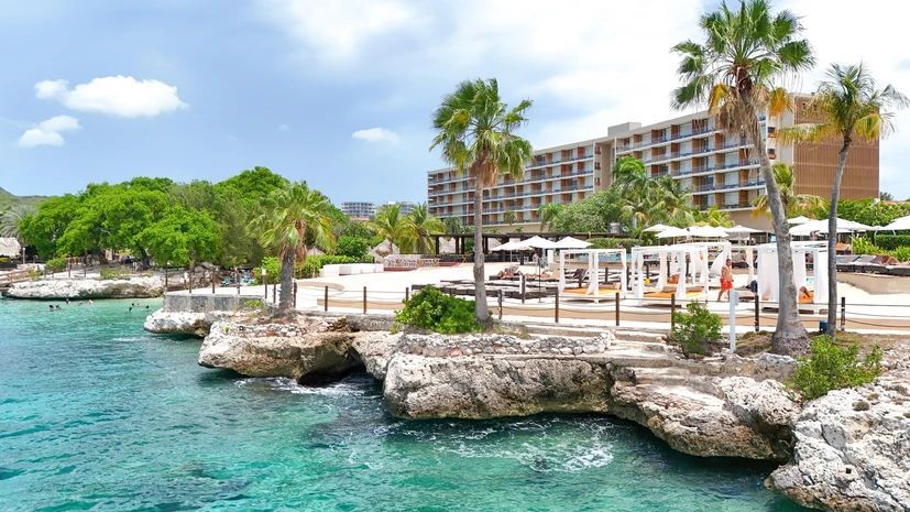 A large building is sitting next to a body of water.