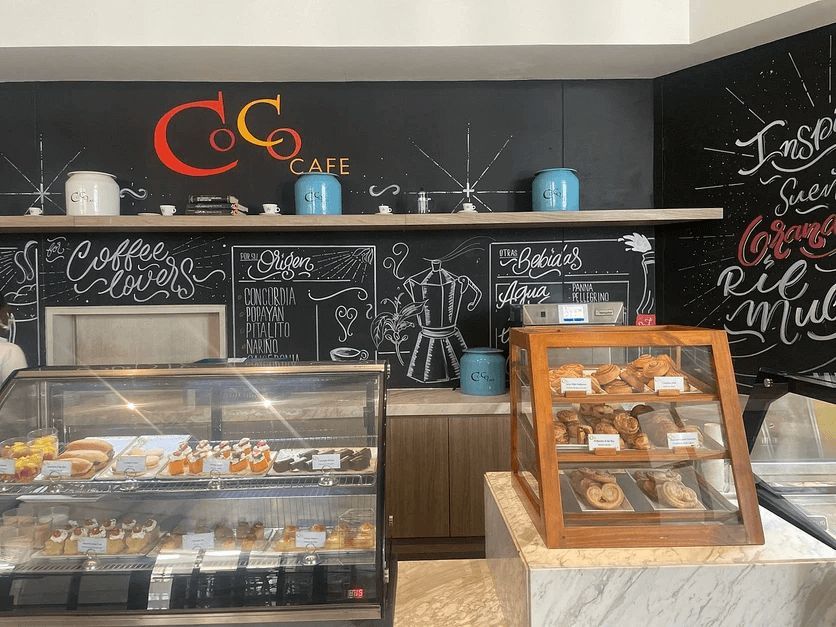 A bakery with a glass display case and a chalkboard wall.