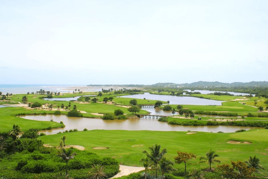 An aerial view of a golf course surrounded by water