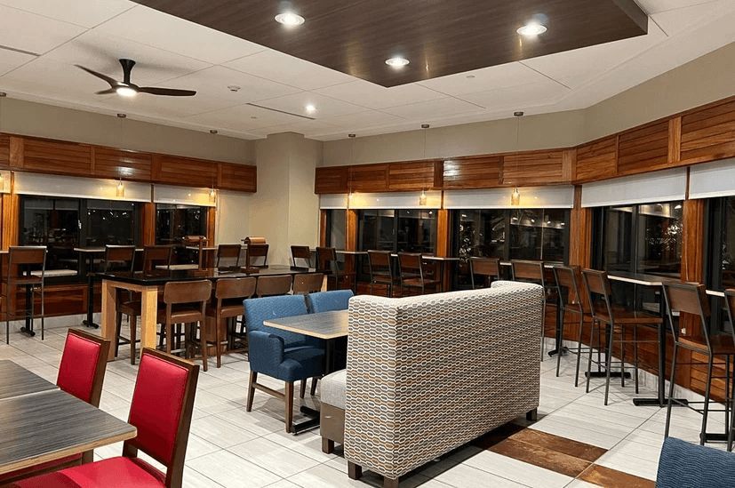 A large dining room with tables and chairs and a ceiling fan.