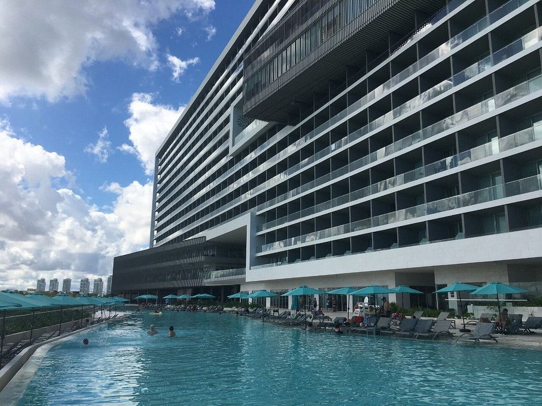 A large building with a swimming pool in front of it.