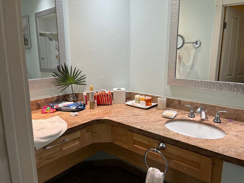 A bathroom with a sink , mirror and towel rack.