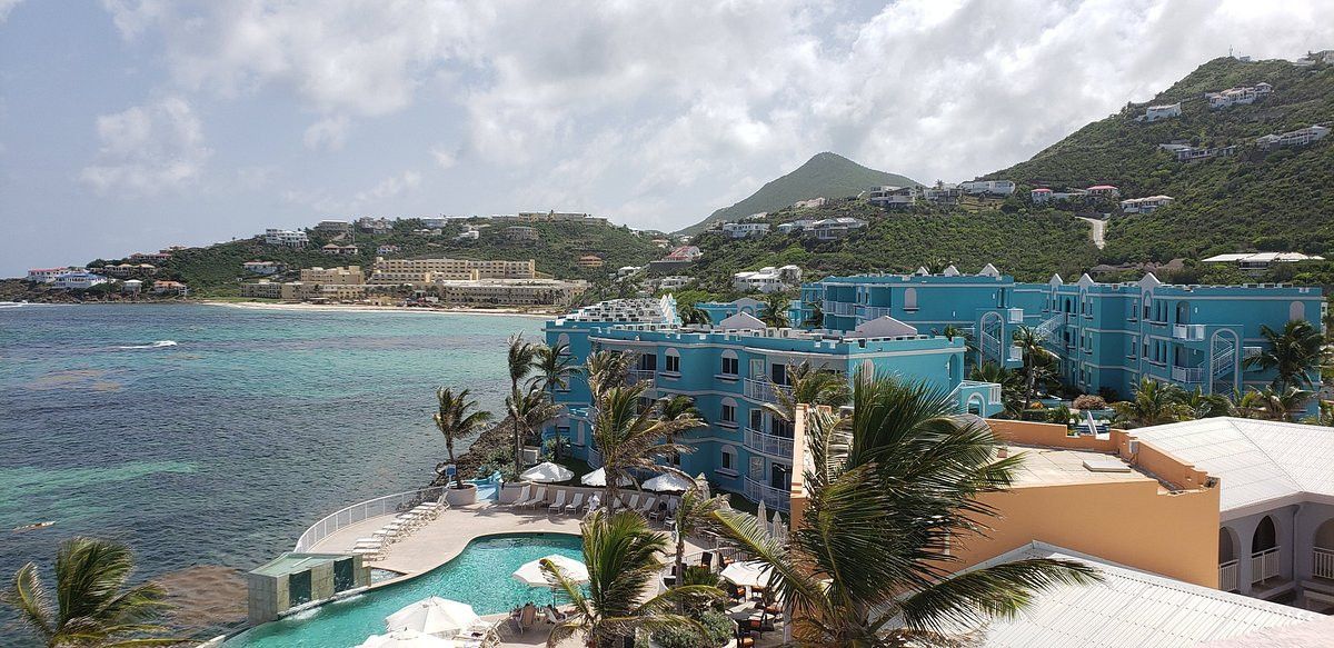 An aerial view of a resort with a pool and a mountain in the background.
