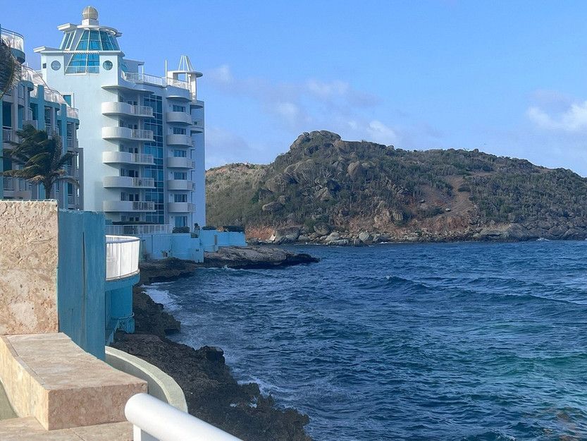 A large blue building sits next to a body of water