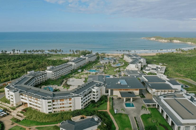An aerial view of a large resort with a beach in the background.