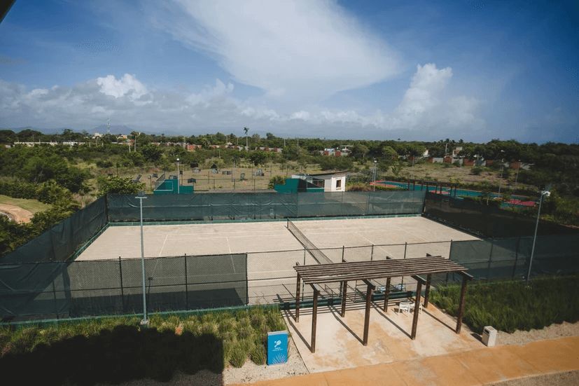 An aerial view of a tennis court with a fence around it.