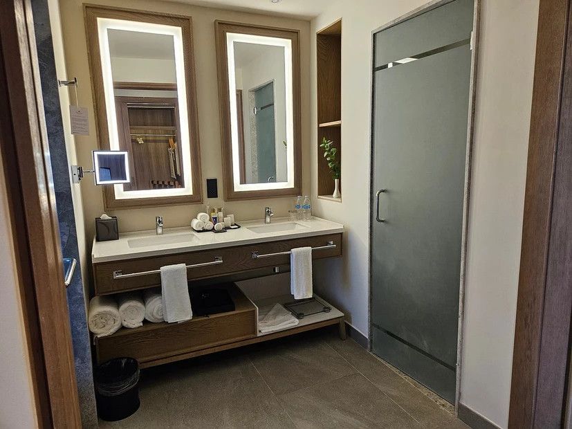 A bathroom with two sinks and two mirrors in a hotel room.