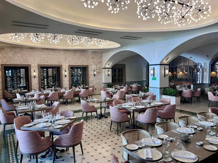 A large dining room filled with tables and chairs and a chandelier.