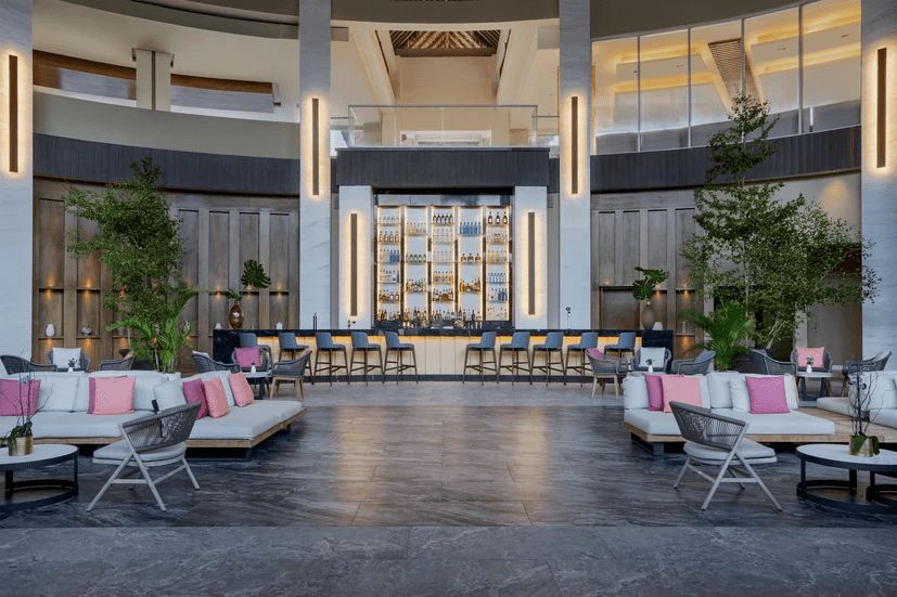 An artist 's impression of a hotel lobby with a bar.