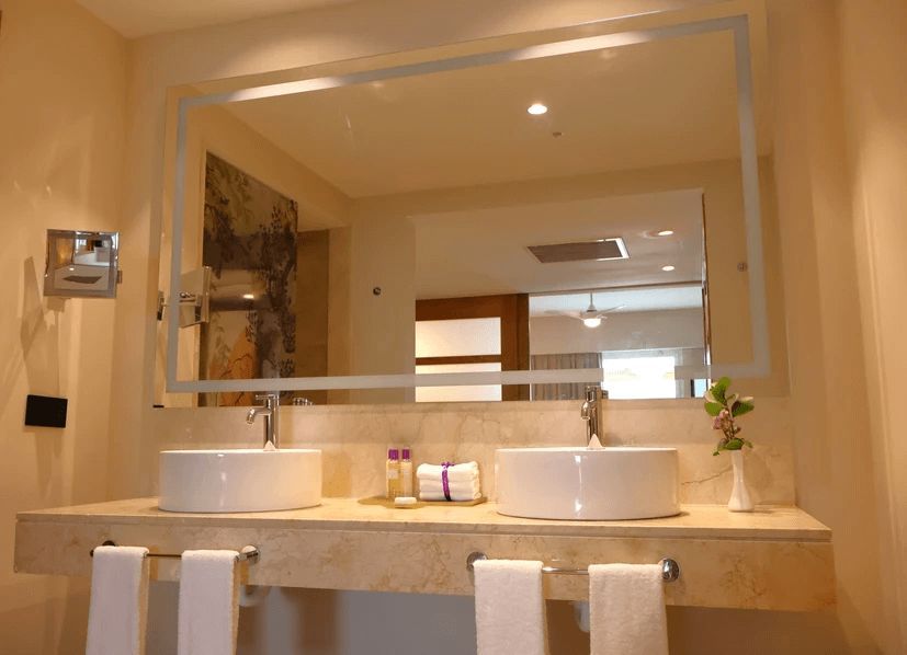 A bathroom with two sinks and a large mirror