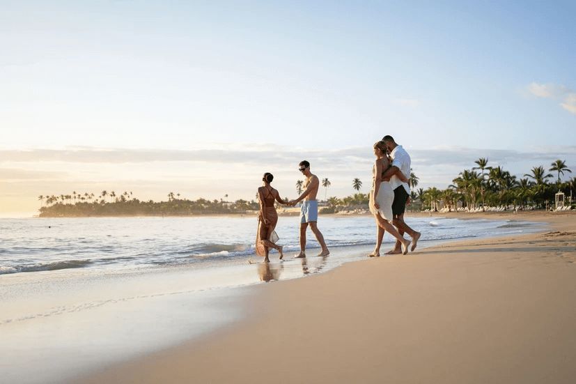 A group of people are walking on a beach.